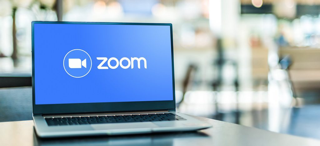 Zoom logo on laptop in hybrid meeting environment.