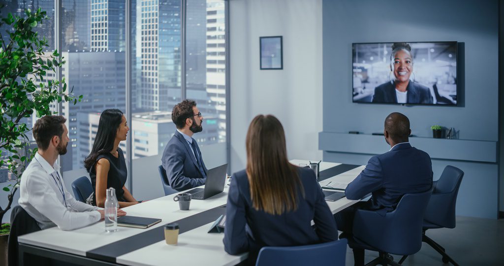 Team members communicating easily in meeting room with automated room testing to ensure proper settings before meetings.