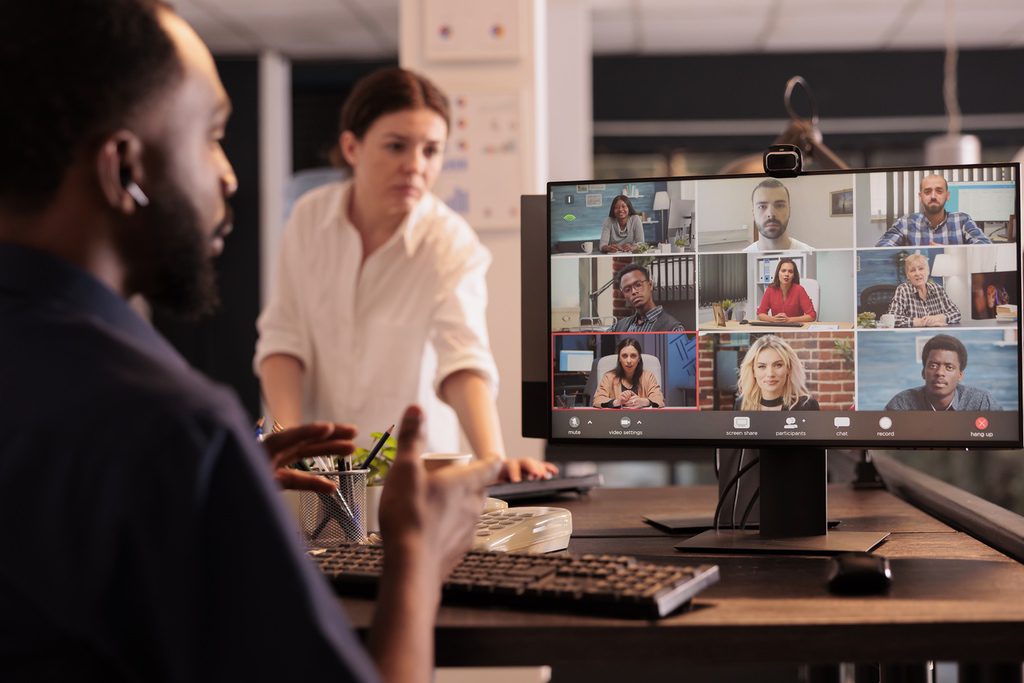 In-office team members in meeting with remote employees via video conferencing system