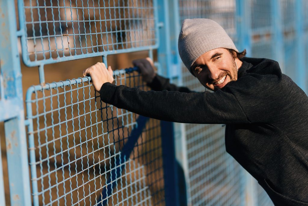 Man leaning on fence after being rehabilitated and released from incarceration