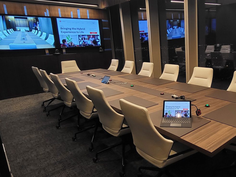 A beautiful modern board room with advanced AV infrastructure, including one-touch join and ultra-wide form factor displays.