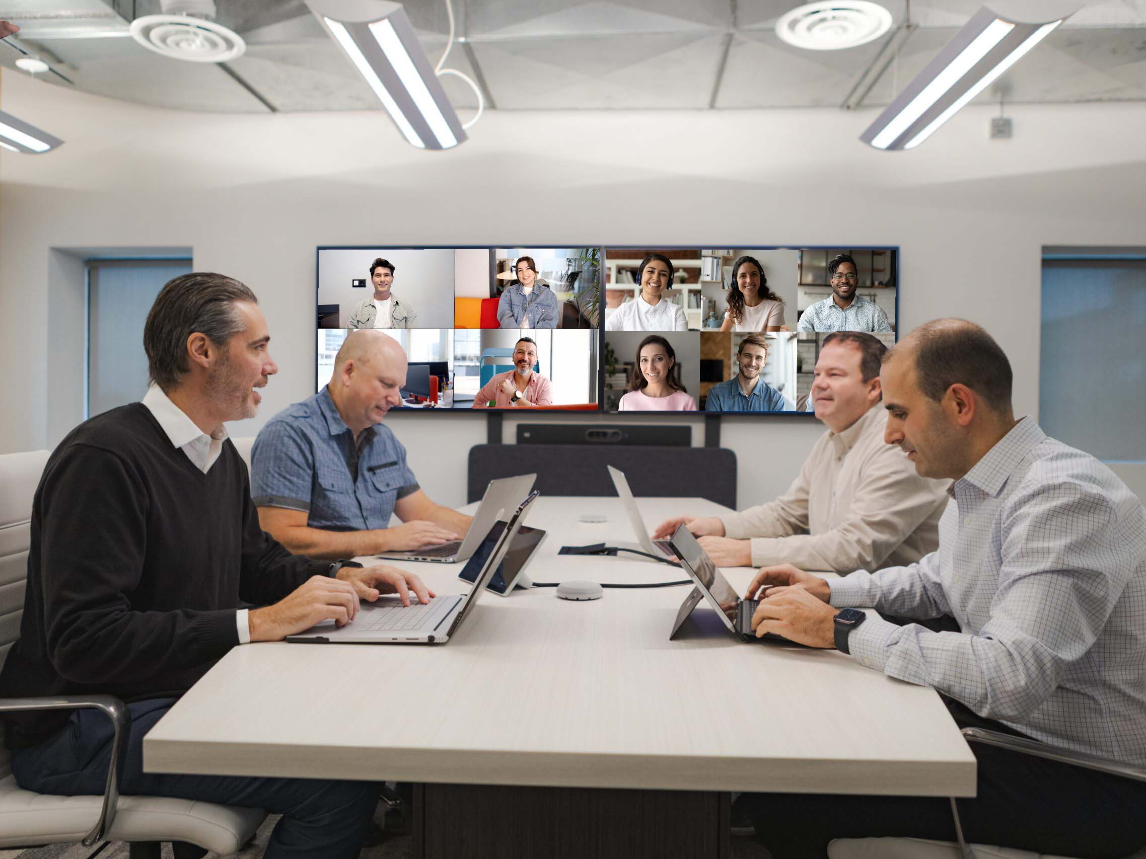 ET Group working in a modern hybrid meeting space with video conferencing and ultra-wide form factor displays.